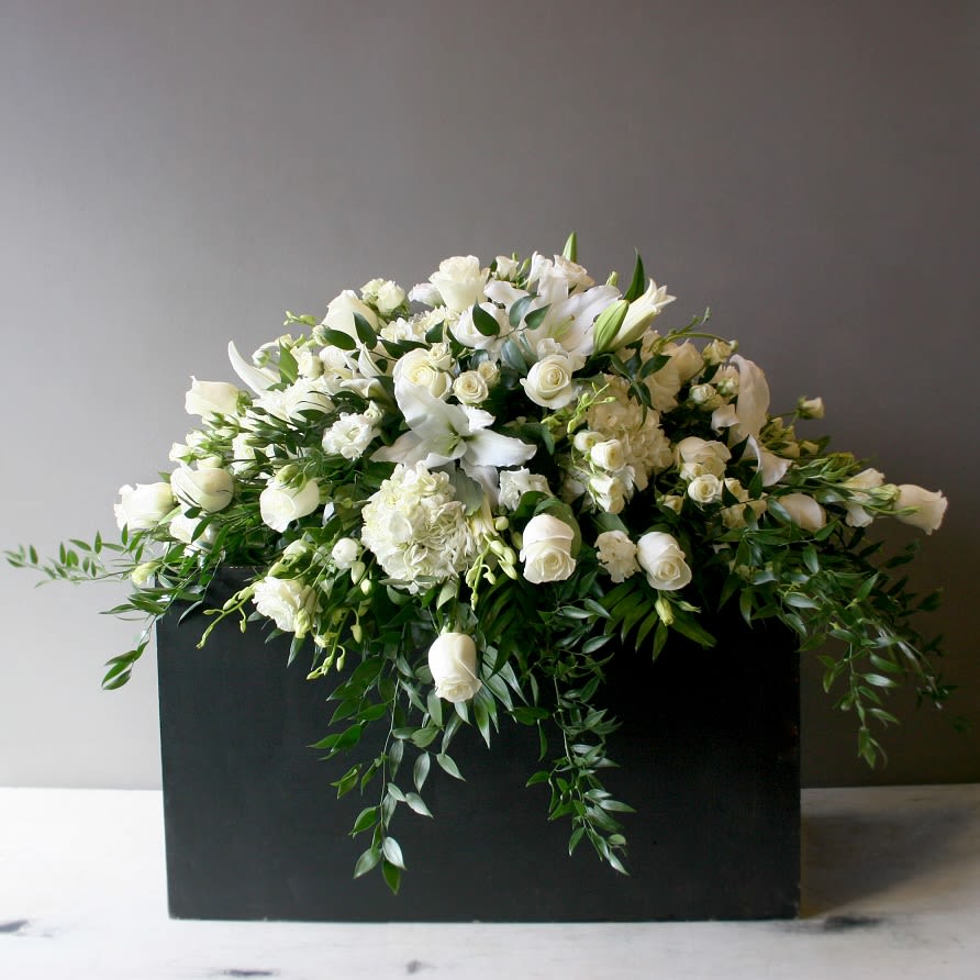 Elegant Tribute Casket Piece - A stunning mix of white flowers to honor your loved one. Mix of hydrangea, roses, dendrobium orchids, lisianthus, and lilies, framed by beautiful greenery.