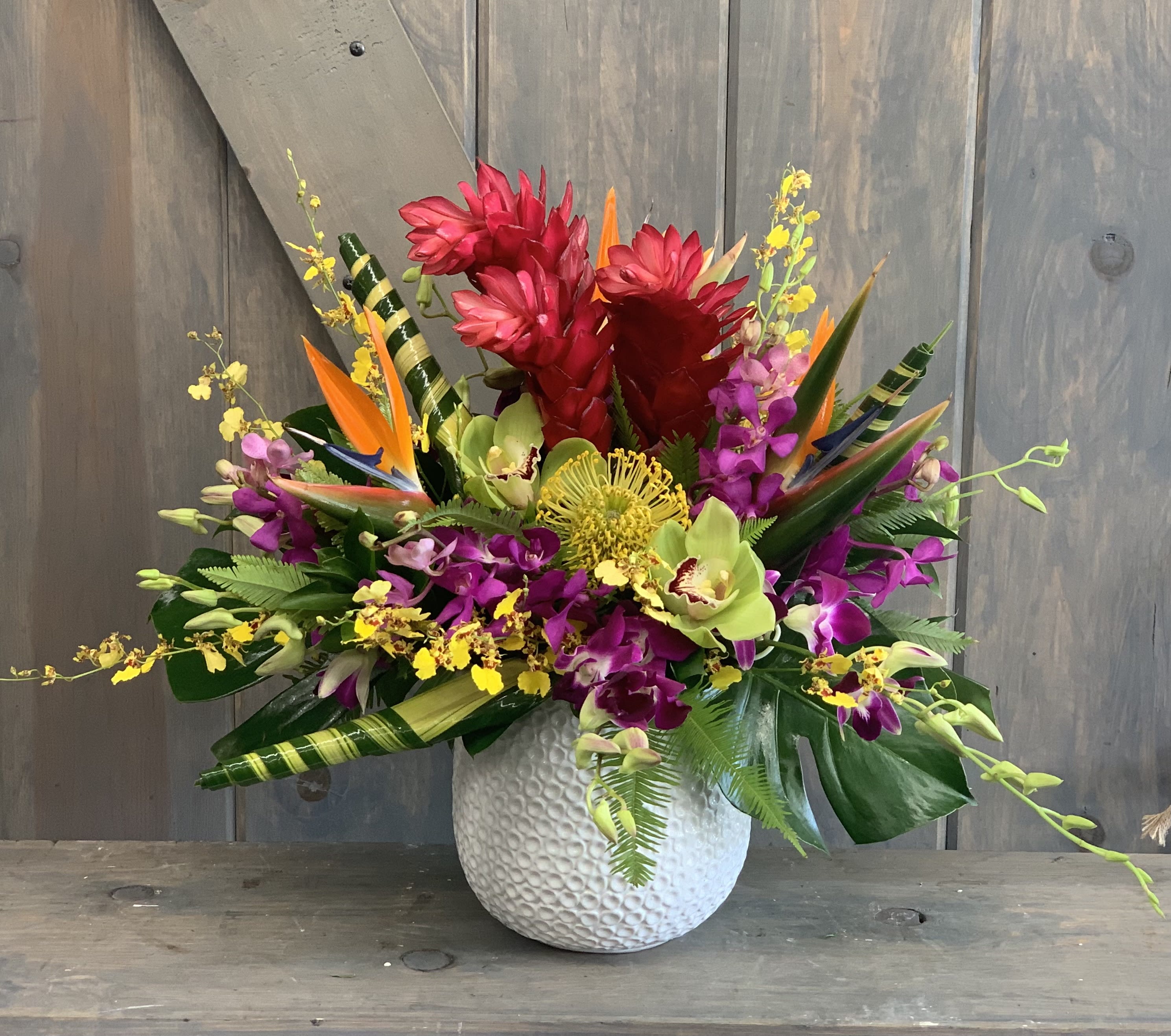 Brilliance  - This tropic delight is packed with amazing Ginger, Birds of paradise, Anthurium, Dendrobium Orchids, Oncidium Orchids, and Protea all within  a beautiful white ceramic container