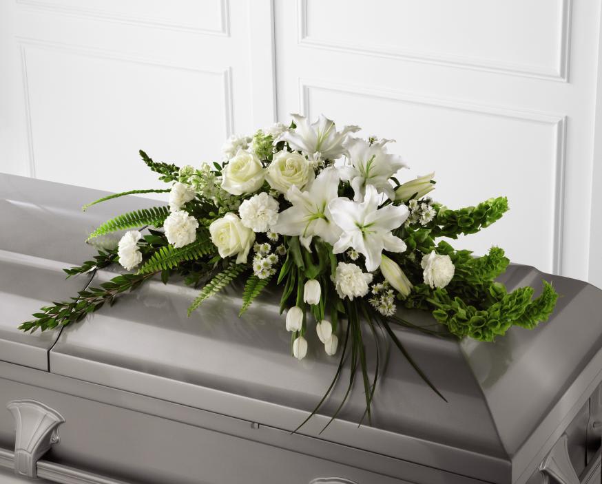 Resurrection Casket Spray - Inspire thoughts of peace and comfort to those wishing to pay their respects for the loss of the deceased.  White tulips, roses, snapdragons, fragrant Oriental lilies, larkspur, carnations and monte casino asters are accented by the bright green stems of Bells of Ireland and an assortment of the finest lush greens to create the perfect arrangement to display on the top of their casket during their final farewell service. Approx. 40&quot; W x 24&quot; D