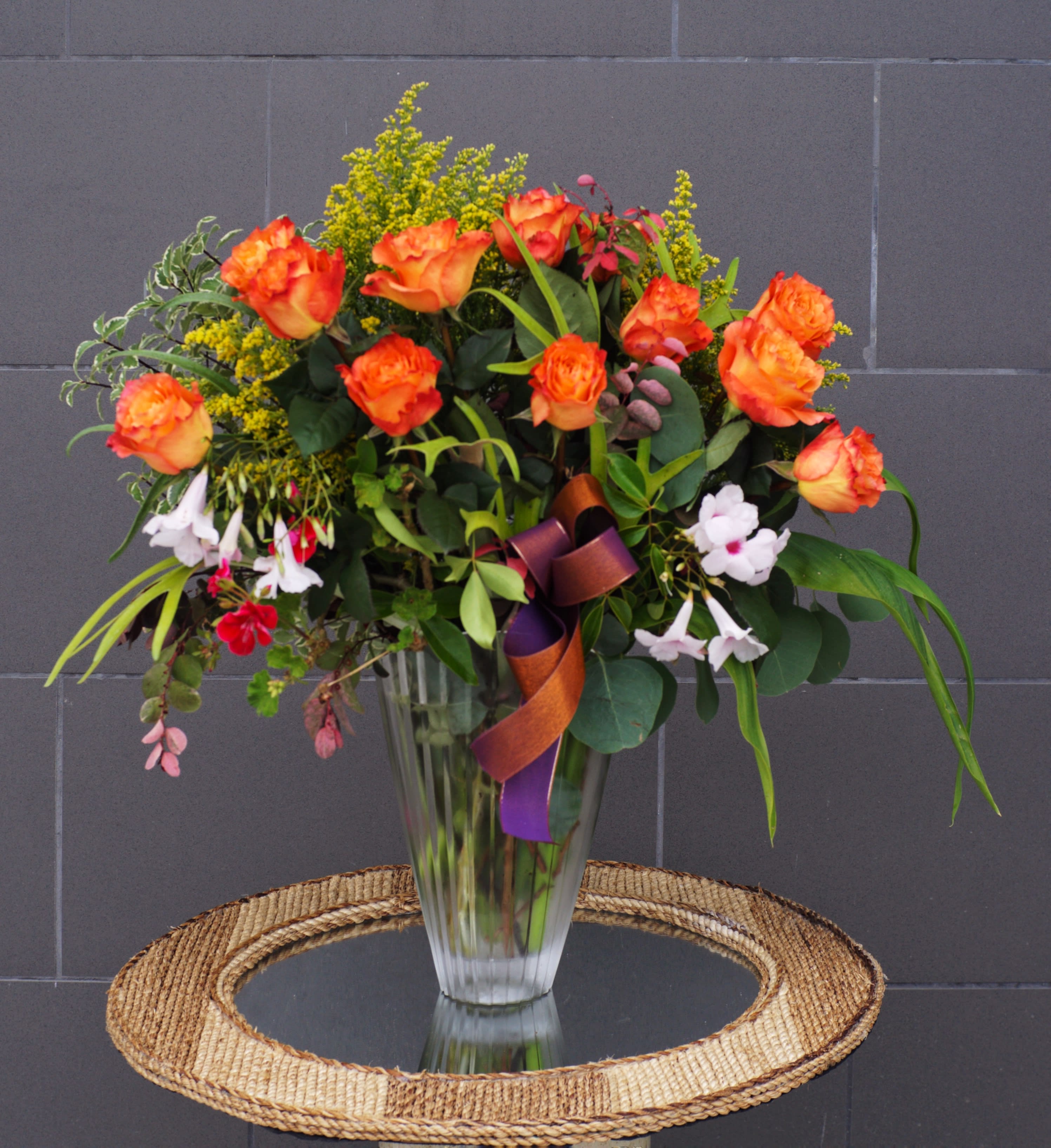 Rose Garden - Beautiful and fragrant Ecuadorian roses and nice accents in a tall glass vase. CUSTOMER CAN CHOOSE ANY COLOR OF ROSES. STANDARD AS SHOWN: 12 ROSES DELUXE: 24 ROSES PREMIUM: 36 ROSES