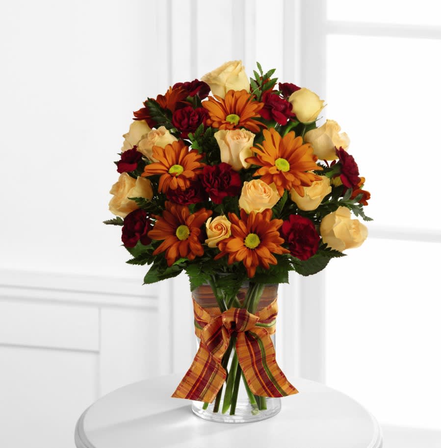 The FTD Golden Autumn Bouquet The FTD Golden Autumn Bouquet - The FTD Golden Autumn Bouquet exudes the warmth and comfort of the harvest season with each colorful bloom. Peach spray roses, burgundy mini carnations, butterscotch chrysanthemums and lush greens are arranged beautifully in a classic clear glass vase accented with an orange plaid ribbon around the neck, creating a truly wonderful bouquet that will send your sweetest sentiments to your special recipient for a fantastic fall.