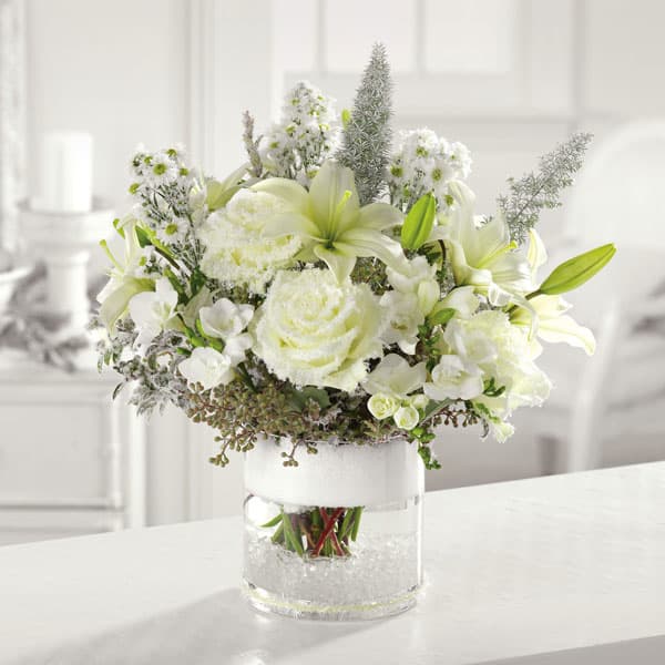 Silence - Snowy white roses, lilies, freesia and mixed greens come together in a glass cylinder vase to bring a sense calm amid the hustle and bustle.