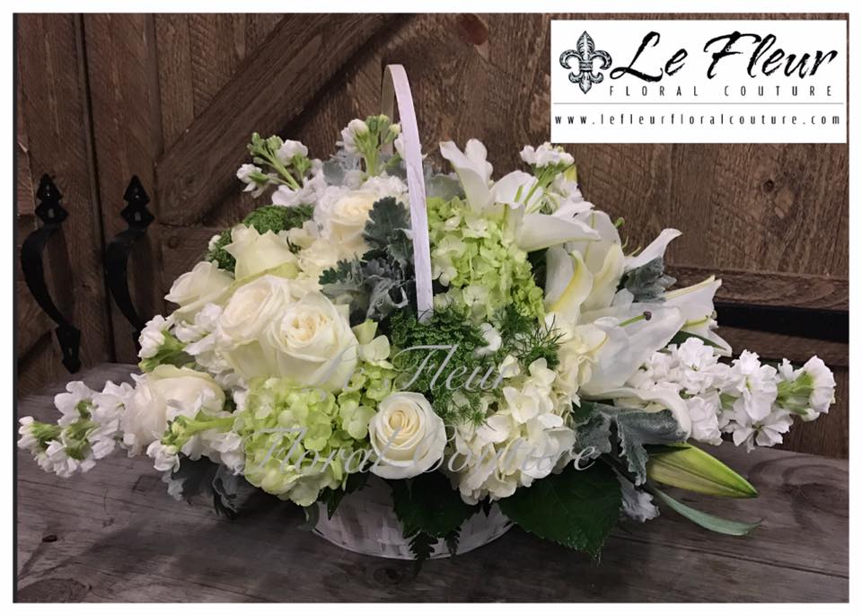 Basket of Serenity - White handle basket fillied with white and green garden hydrangeas, white lilies, white stock and white vintage roses and accented with green mist and dusty miller.
