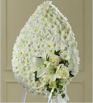The FTD® Solace™ Teardrop The FTD® Solace™ Teardrop - You can be sure that this exquisite expression of sympathy, crafted in the white of heavenly hope, will make a moving and impressive addition to a wake, funeral or burial service. Reflecting the form of a "teardrop", this generously scaled spray constructed by a local FTD artisan florist includes white pompons, roses and Asiatic lilies accented with a white satin ribbon bow. It comes on a metal stand to give it the ultimate flexibility for display at a funeral home, in a church or at a cemetery. Your purchase includes a complimentary personalized gift message.