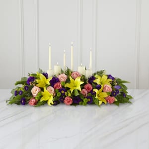 The FTD Forever Arrangement The FTD Forever Arrangement - This inspirational altar piece handcrafted by a local FTD artisan florists makes an inspired contribution to a funeral service – one that truly shows how much you care. Handcrafted by a local FTD artisan florist of peach and coral roses purple lisianthus and asters yellow Asiatic lilies and lush green accents in a long low arrangement it makes a natural setting for a variety of candles (included). As an accompaniment to a funeral it’s an excellent choice for most services both elaborate and simple.