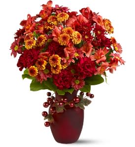 Napa Sunshine - A mix of bright blooms, including chrysanthemums in bold fall colors of red and bronze, creates a striking display - especially when arranged in a cranberry glass vase adorned with dark, glossy grapes. It's the spirit of autumn in the Napa Valley, gathered up and presented in a vase!