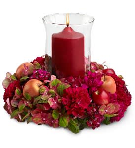 Fruitful Season Fruitful Season - Celebrate the season's bounty and give thanks for all the good things in life with a red and burgundy blend of fresh flowers and artificial apples, arranged around a clear glass hurricane that holds a red pillar candle. This ruby-toned display makes a beautiful centerpiece for any Thanksgiving or fall occasion.