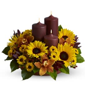 Rustic Radiance Rustic Radiance - This rustic display of three chocolate-colored pillar candles surrounded by bright sunflowers, orchids and more, in glowing tones of yellow and bronze, makes a delightful centerpiece for a Thanksgiving feast or fall dinner party, and is also a lovely decorative accent for an entryway.