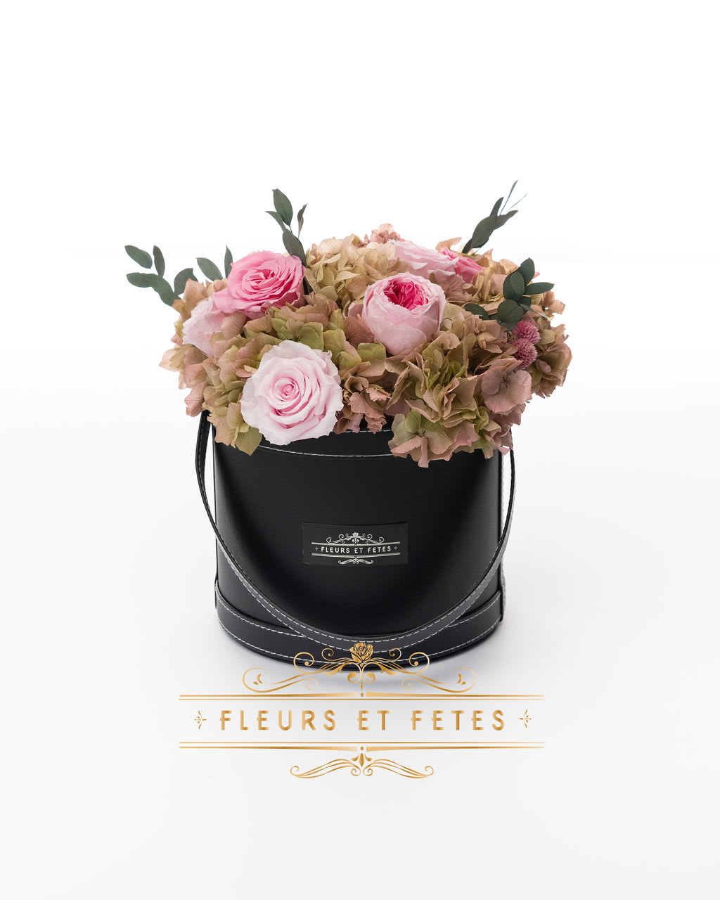 Medium vegan leather box with mixed garden flowers - This timeless arrangement is a part of our Eternity Collection and features real roses, hydrangeas, and greens that last up to one year. Set in our hand-stitched vegan leather round box.    **Please note that variations will occur since all of our arrangements are handmade by our in-house designers.**    Caring for Preserved Roses:  1. Do not water the arrangement 2. Keep the arrangement indoors 3. Keep the arrangement out of direct sunlight 4. Keep the arrangement in a cool, dry place 5. Do not crush, press, or fold the petals.