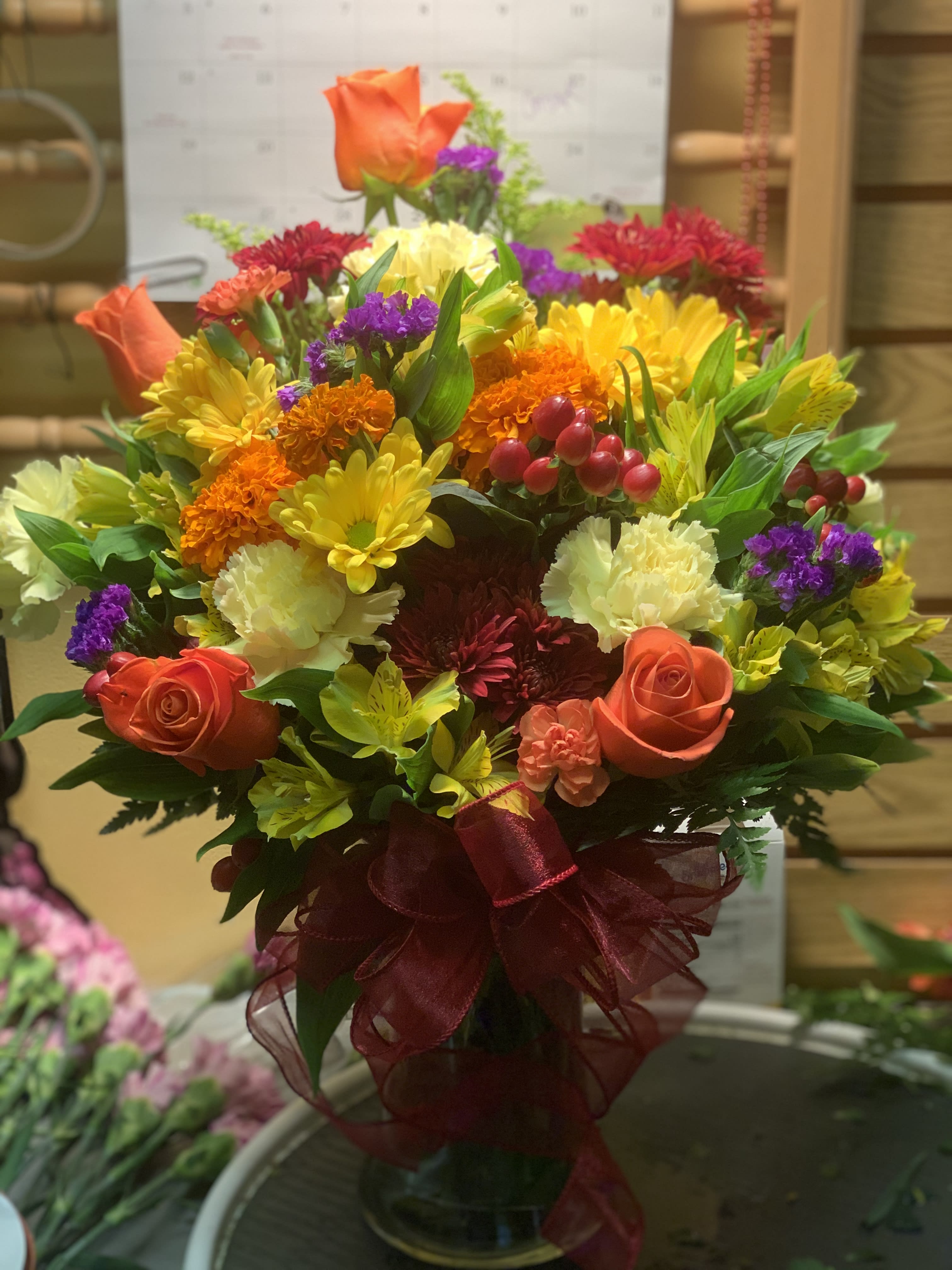 Indian Summer - Bright blooms slide into fall in one of our many glass vases. A variety of multicolor fresh blooms.