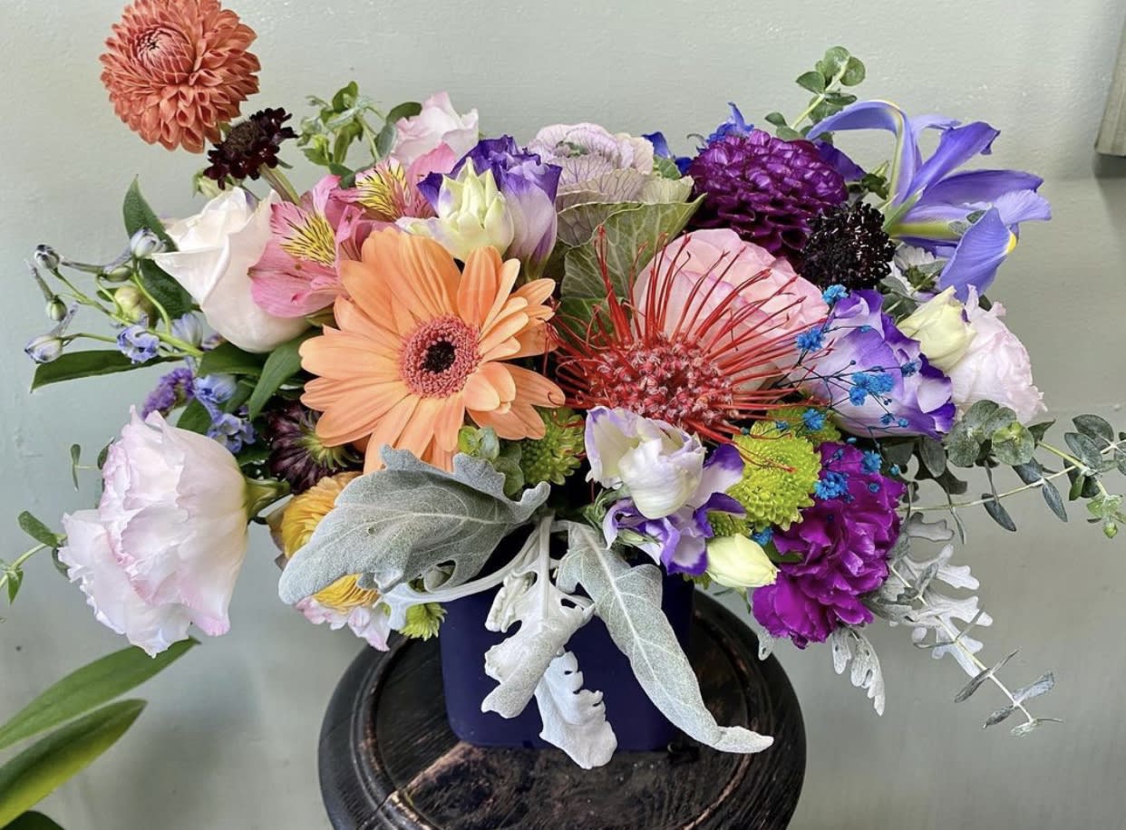 Tresured Aroma Tresured Aroma - Gerber daisies, dahlias, iris, lisianthus, alstroemeria, dusty miller, blue delphinium, ranunculus, etc all hand arranged in ceramic vase.