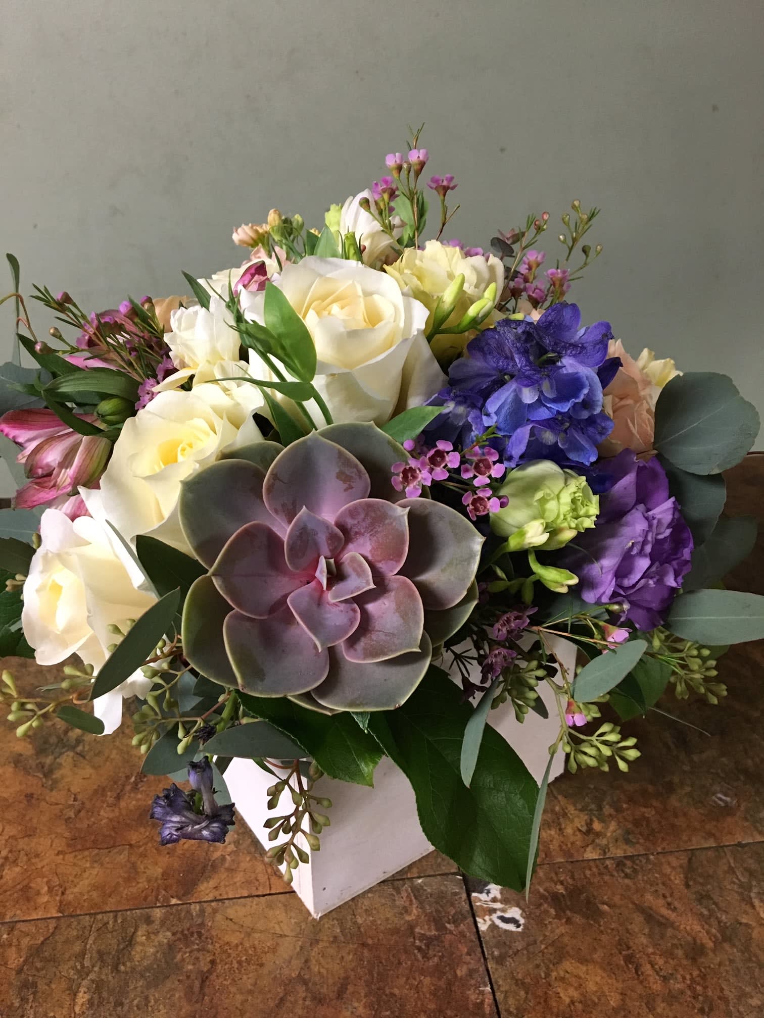 Morning Breeze Morning Breeze - This beautiful arrangement is arrange with lovely greens, white roses, eucalyptus, lisianthus and a lovely succulent to bring a smile to a special someone.