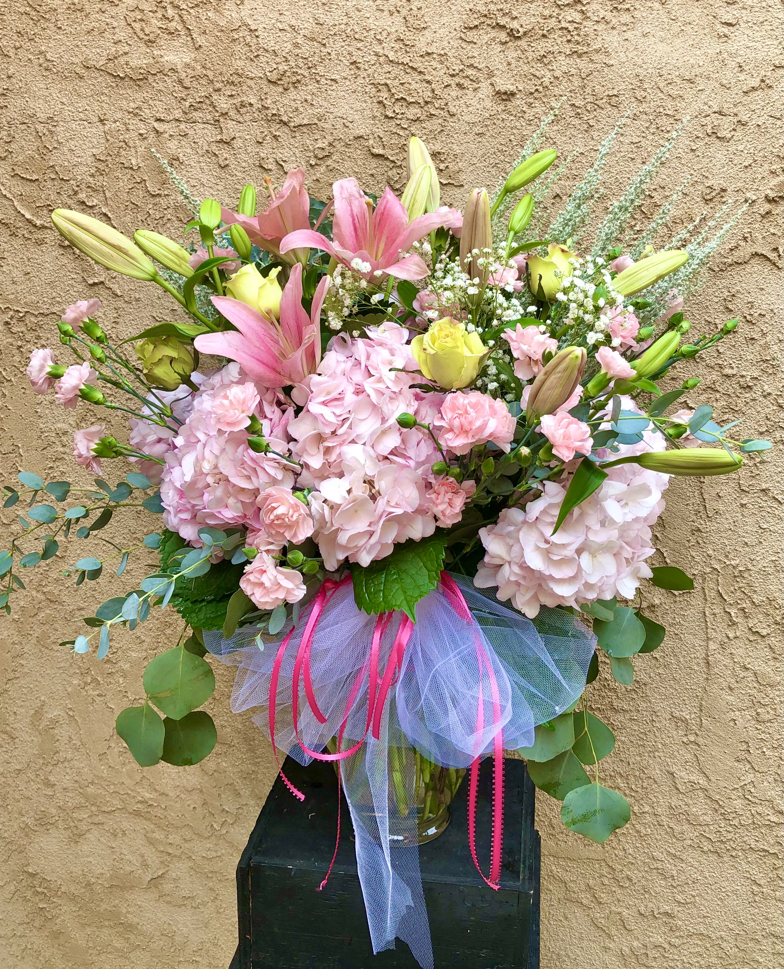 Blushing Blooms - An elegant and vibrant arrangement with pink lilies, hydrangeas, carnations, and green accents.