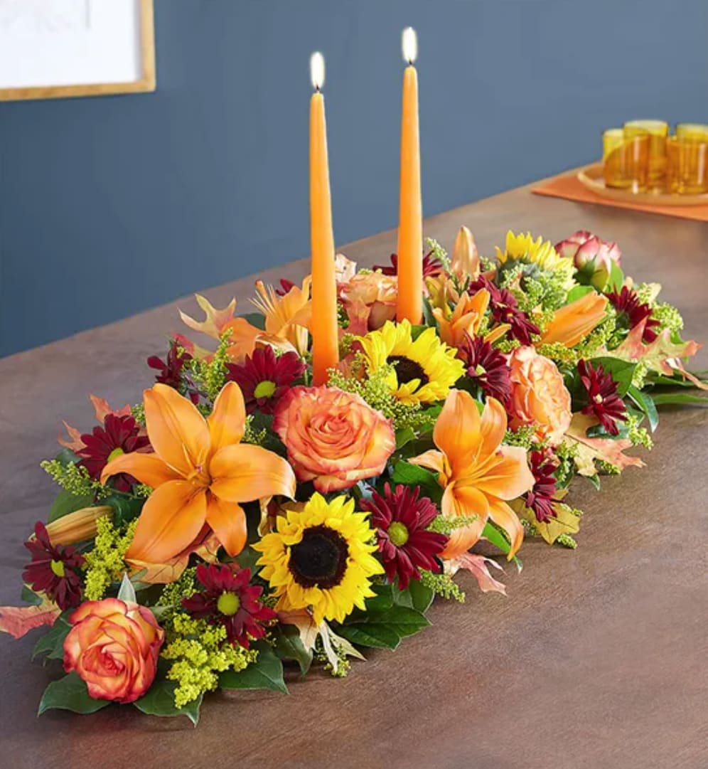 Fields Of Europe® For Fall Centerpiece - The rich beauty of the European countryside comes alive in our best-selling fall centerpiece. Crafted by our artisan florists, it’s filled with a gathering of fresh-picked blooms in brilliant colors and finished with an orange candle to warm hearts and homes.