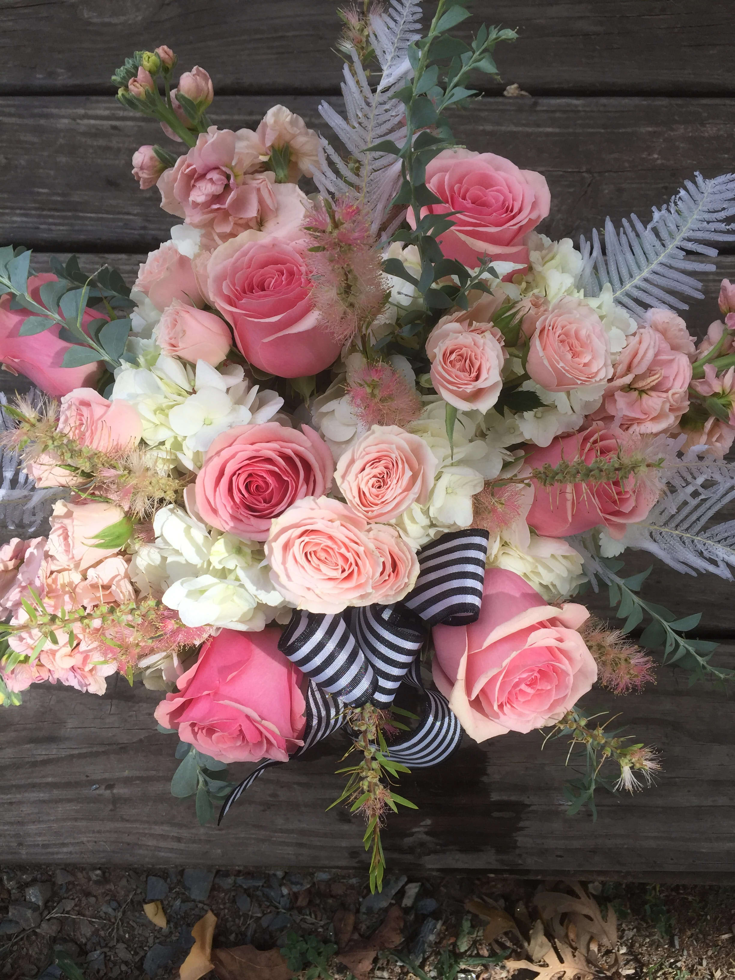 Sweet Serenity - A bouquet with hydrangea, roses, stock and bleached feathers, with black and white stripped ribbon.