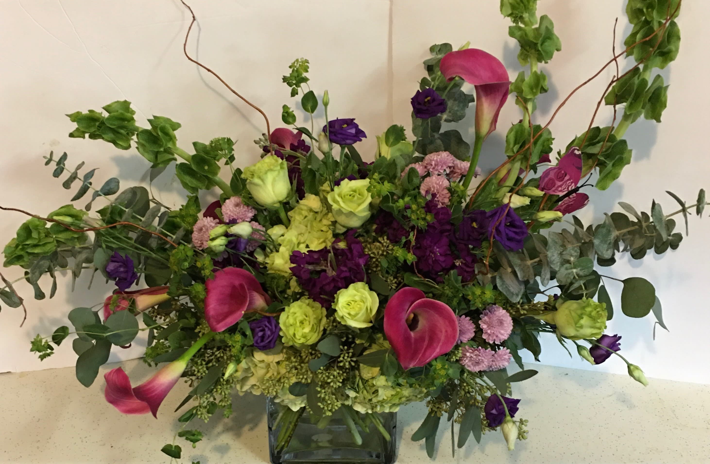 In The Garden - Bells of Ireland, roses, mini calla lillies, hydrangea and lisianthis in a cube vase.