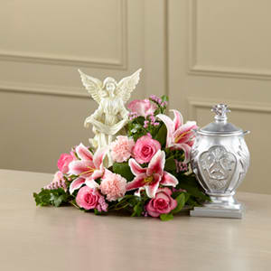 The FTD® Divinity™ Arrangement - This extraordinary mixed flower bouquet delivers your sympathy with a beauty and faith that reflects the love and loss you feel. The asymmetrical bouquet is hand-arranged by a local FTD artisan florist to make a reverent and respectful setting for an urn of the deceased’s cremated remains. Around an angel sculpted of artist’s resin are white roses, carnations, Stargazer lilies, statice and lush greens in a tabletop container that’s not visible when set on a flat surface. It makes a fitting focal point for a wake or funeral service.