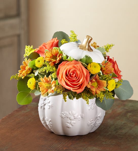 Plentiful White Pumpkin™ 2021 - A plentiful mix of blooms gives our autumn arrangement an undeniable charm. Loosely gathered with traditional pops of red, orange and yellow, it’s the perfect contrast to our modern-styled pumpkin. Featuring a white satin finish, embossed detail and rich golden accents, this harvest-inspired container is an ideal pick for fresh flowers, wrapped candies or as a cozy seasonal accent.