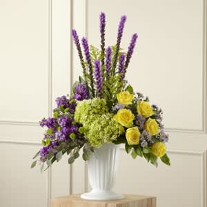 The FTD® Affection™ Arrangement  - Contrasting blooms of purple, green and yellow create an original and beautiful expression of sympathy and sorrow, eminently appropriate for celebrating a life that has passed. This stately arrangement handcrafted by a local FTD artisan florist features an eye catching silhouette of purple liatris stretching heavenward surrounded by yellow roses, purple stock, lavender Monte Casinos and green hydrangea and button poms in a pedestal urn with the look of fine white ceramic. This “statement bouquet” makes a welcome addition to a wake, funeral or graveside burial service.