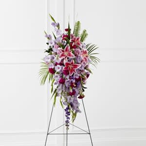 The FTD® Tender Touch™ Standing Spray - The FTD® Tender Touch™ Standing Spray creates an elegant display of beauty and color to enhance their final tribute. Lavender gladiolus, Stargazer lilies, fuchsia carnations, purple larkspur, lavender Peruvian lilies, lavender chrysanthemums, sword fern fronds, emerald palm fronds and other assorted greens are gorgeously arranged to create a sophisticated standing spray. Displayed on a wire easel, this arrangement will add to the sophistication of their service with each fragrant bloom.