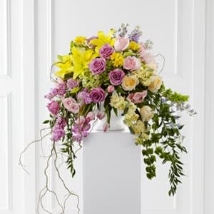 The FTD® Display of Affection™ Arrangement - The FTD® Display of Affection™ Arrangement is an exquisite way to commemorate the life of the deceased. Lavender roses, yellow stock, pink stock, pink tulips, yellow roses, pink roses, pink spray roses, lavender larkspur, Bells of Ireland, yellow freesia, yellow Asiatic Lily, blue delphinium, green hydrangea and lush greens are accented with curly willow branches and arranged to create a sophisticated display that radiates elegance and grace at their final farewell service.