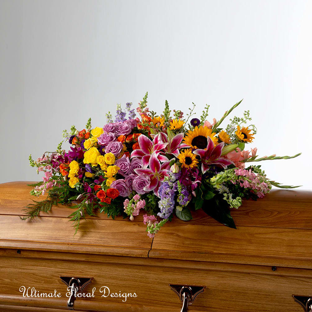 Everlasting Spring  - A full celebration of colors, this multi-flower and bright casket spray is representative of a life lived to its fullest. Colors and flowers may change based off of season and availability. 