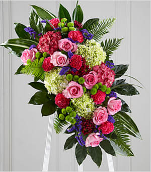 The FTD® Refreshing Mix™ Standing Spray - This glorious celebration of life combines the vibrant, hopeful colors of spring in a standing arrangement designed to inspire happy memories of times gone by. Handcrafted by a local FTD artisan florist of bright and beautiful blossoms that include pink roses, magenta carnations, purple statice and hydrangeas, green button pompons and hydrangeas and daisy pompons all arranged against a background of lush green aralia and aspidistra leaves. It is designed for display on an easel making an impressive, memorable expression of sympathy at a wake, funeral or graveside service.  Your purchase includes a complimentary personalized gift message.