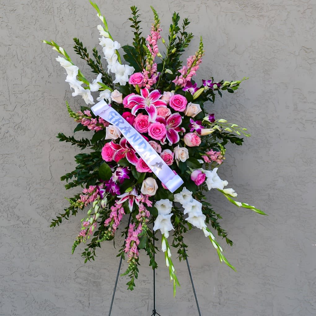 IN LOVING MEMORY STANDING SPRAY  - OUR IN LOVING MEMORY STANDING SPRAY comes with glads, snapdragons dendro, pink oriental lilies &amp; pink/cream roses !!  Approximate size 3' by 2' wide and comes with an easel. (Personalize Ribbon are an additional fee of $20)