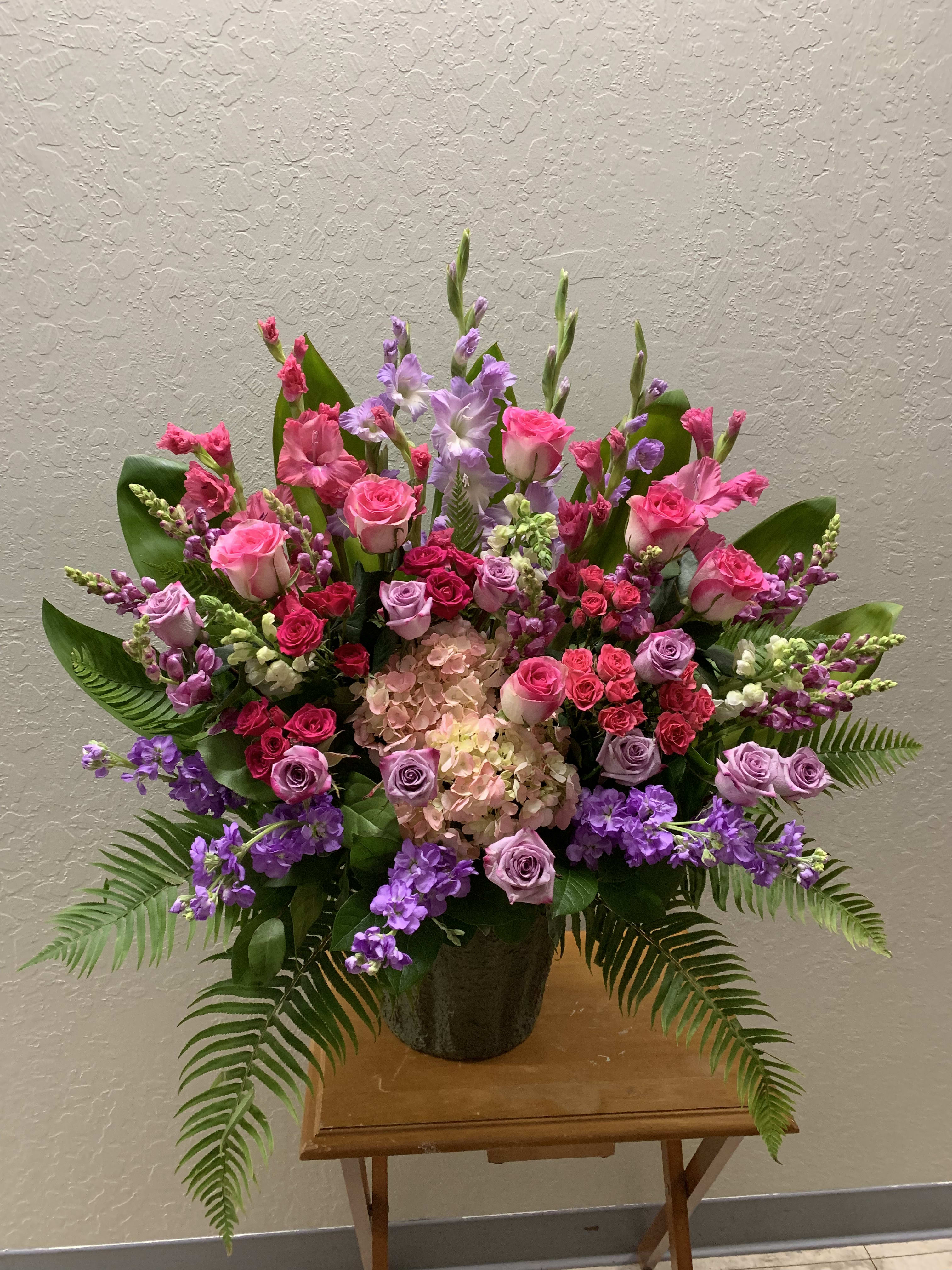 FB#12 Purple and Pink Precious Tribute Basket - This purple and pink arrangement features roses, spray roses, hydrangeas, snapdragons, gladiolus, stock, and mixed foliage.  The arrangement is approximately 24&quot; H and 24&quot; W.