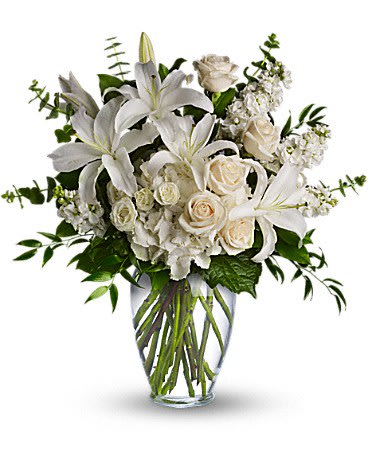 Dreams Bouquet All White  - A mixed  variety of white and Ivory blossoms sends you hope and strength. Beautifully. designed. Beautiful flowers such as white hydrangea, spray roses and stock, white roses, and seasonal flowers along mixed textures.  eucalyptus, dusty miller and more fill a tall glass vase.