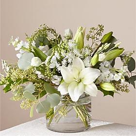 Alluring Elegance - An illuminating array of florals brings an air of elegance to any room it's placed. This arrangement features refined florals like lilies, Queen Anne's Lace and Veronica in a clear glass vase to add a touch of sophisticated style to your special occasions.