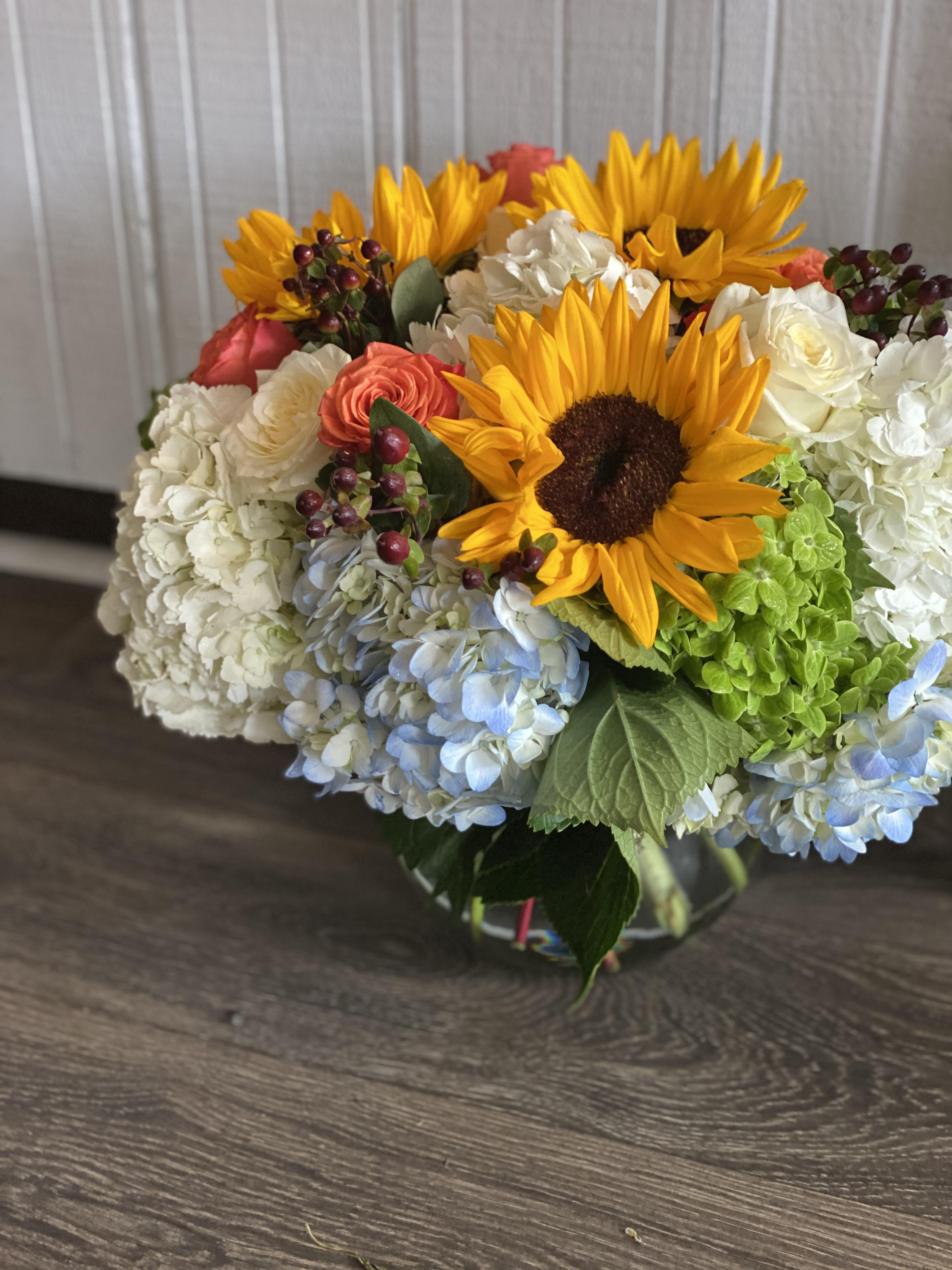 Sunflower Fields Sunflower Fields - Hydrangea, sunflowers, and orange roses arranged in a vase