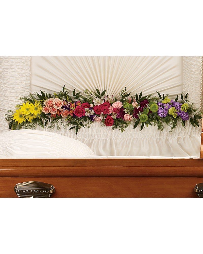 Glorious Memories Garland - Create a beautiful resting place with this magnificent garland of roses and other floral favorites artistically placed at the base of the casket lid. The exquisite arrangement includes hot pink spray roses, peach spray roses, light pink alstroemeria, pink miniature carnations, yellow daisy spray chrysanthemums, purple button spray chrysanthemums, green button spray chyrsanthemums, orange snapdragon, lavender stock and purple sinuata statice, accented with assorted greenery.