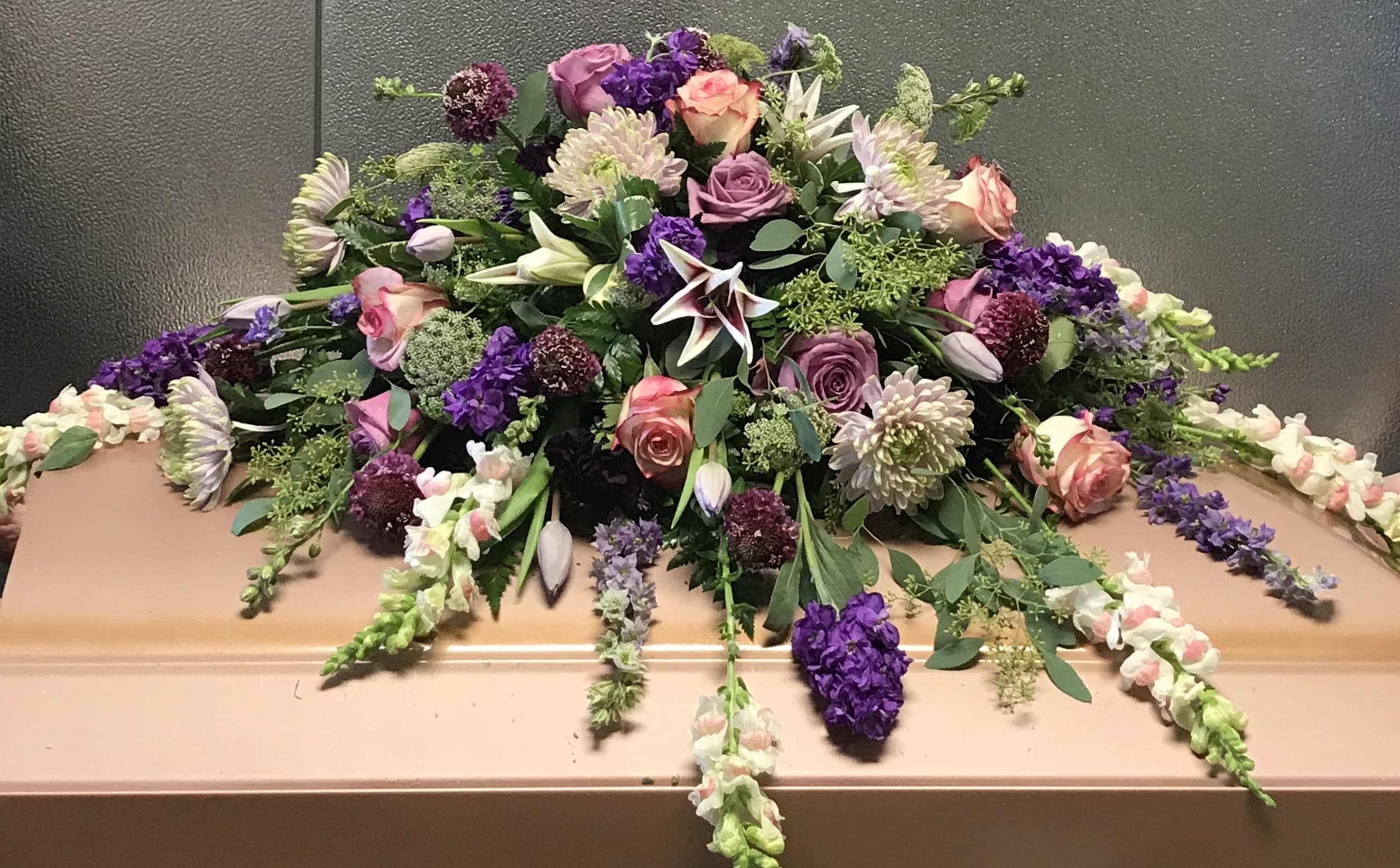 Lavender and Pink Spray Lavender and Pink Spray - Purple salvias, purple perennials, pink roses, greenery and much more make up this beautiful casket spray