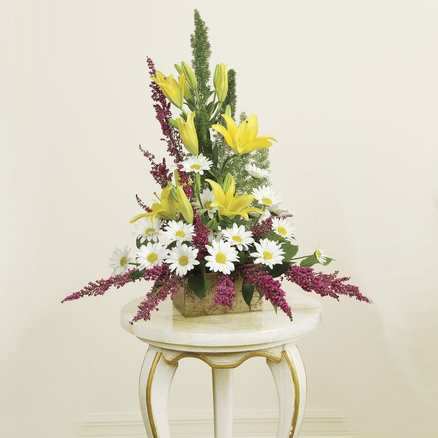 LILIES AND HEATHER IN FOND MEMORIES - Lilies, Heather and others beautifully arranged with mixed greenery and arrayed as an 'A' line arrangement. 