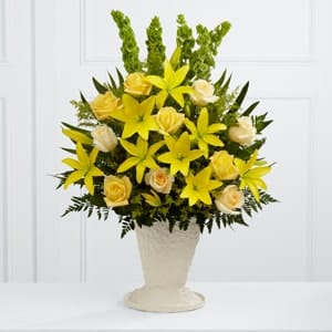 The FTD® Golden Memories™ Arrangement The FTD® Golden Memories™ Arrangement - The FTD® Golden Memories™ Arrangement bursts with sunlit beauty to honor the life of the deceased. Brilliant yellow Asiatic lilies, roses and solidago are offset by cream roses, Bells of Ireland, teepee palm fronds and lush greens to create a dazzling display. Arranged in a large papier mache urn, this incredible presentation of floral grace will bring a cheerful elegance to their final farewell service.