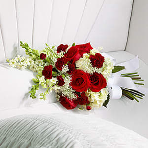 The FTD® Forever in Our Hearts™ Casket Adornment -  The FTD® Forever in Our Hearts™ Casket Adornment is a beautiful accent piece that adds that extra touch of elegance to their final farewell service. Red roses and mini carnations are eye-catching and bright arranged amongst white hydrangea, larkspur, snapdragons and Queen Anne's Lace. Tied together with a white grosgrain ribbon, this gorgeous bouquet is a lovely way to say goodbye to your beloved. 