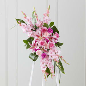 The FTD® Sweet Farewell™ Standing Spray -  When your feelings of loss and sorrow compel you to make a grand gesture of sympathy, this dramatic, standing arrangement is a lovely way to convey your sincerest condolences. This extraordinary composition of pink blooms and lush greens handcrafted by an FTD artisan florist includes roses, carnations, gladiolus and Stargazer lilies set among lush, contrasting greenery. Made to be displayed on an easel, it makes an appropriate choice for a wake, funeral or graveside service, sure to be much appreciated and long remembered. 