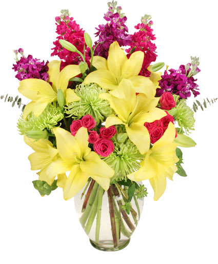 Flor-Elaborate Bouquet - Yellow lilies steal the show in this kaleidoscope of colors with green ‘Fuji’ spider mums, fuchsia miniature spray roses, and purple stock! Order this vibrant arrangement and have them saying, “Goodbye, Winter! Hello, Spring!”