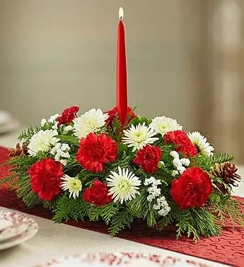 Classic Christmas Centerpiece - Our traditional table arrangement creates the perfect centerpiece for your Christmas celebration. Beautifully designed with long-lasting blooms in seasonal colors, this fragrant gathering features red taper candles to cast a warm, cozy glow throughout the holidays.