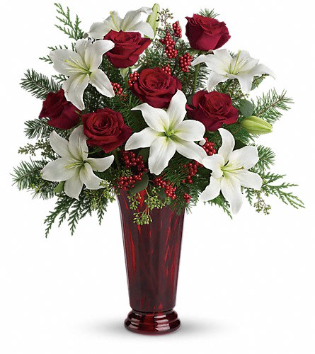 Holiday Magic Holiday Magic - With beautiful red roses and brilliant white lilies delivered in a dramatic tall ruby vase this dazzling holiday arrangement casts an enchanting spell. A step up from the traditional its effect is nothing less than magical. White asiatic lilies red roses fir cedar and eucalyptus create the perfect holiday bouquet especially when delivered in a stunning ruby red roman column vase.Approximately 20" W x 22 1/2" H Orientation: One-Sided As Shown : T117-1ADeluxe : T117-1BPremium : T117-1C