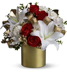 Teleflora's 24 Karat Bouquet Teleflora's 24 Karat Bouquet - The Christmas holidays bring golden memories and 24-karat reminiscences of family and friends; and this dazzling mix of scarlet roses and fragrant white blossoms - interwoven with golden accents and a shiny ribbon - will bring a touch of joy and beauty to any gathering. Red roses and a mix of white blossoms such as Oriental lilies, carnations and alstroemeria – accented with gold-sprayed leaves and evergreens, plus a golden ribbon – are delivered in a gold-colored Teleflora Satin Collection Cylinder. Approximately 12" (W) x 13" (H) Orientation: All-Around