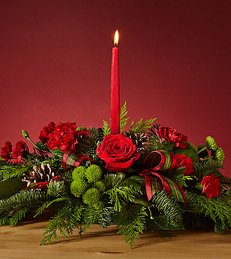 BY THE CANDLELIGHT CENTERPIECE - Let time fly By the Candlelight centerpiece as new holiday memories are made. What better way to commemorate the joyful homecoming than with classic red roses and lush evergreen accents?    Please Note: The bouquet pictured reflects our original design for this product. While we always try to follow the color palette, we may replace stems to deliver the freshest bouquet possible, and we may sometimes need to use a different vase.