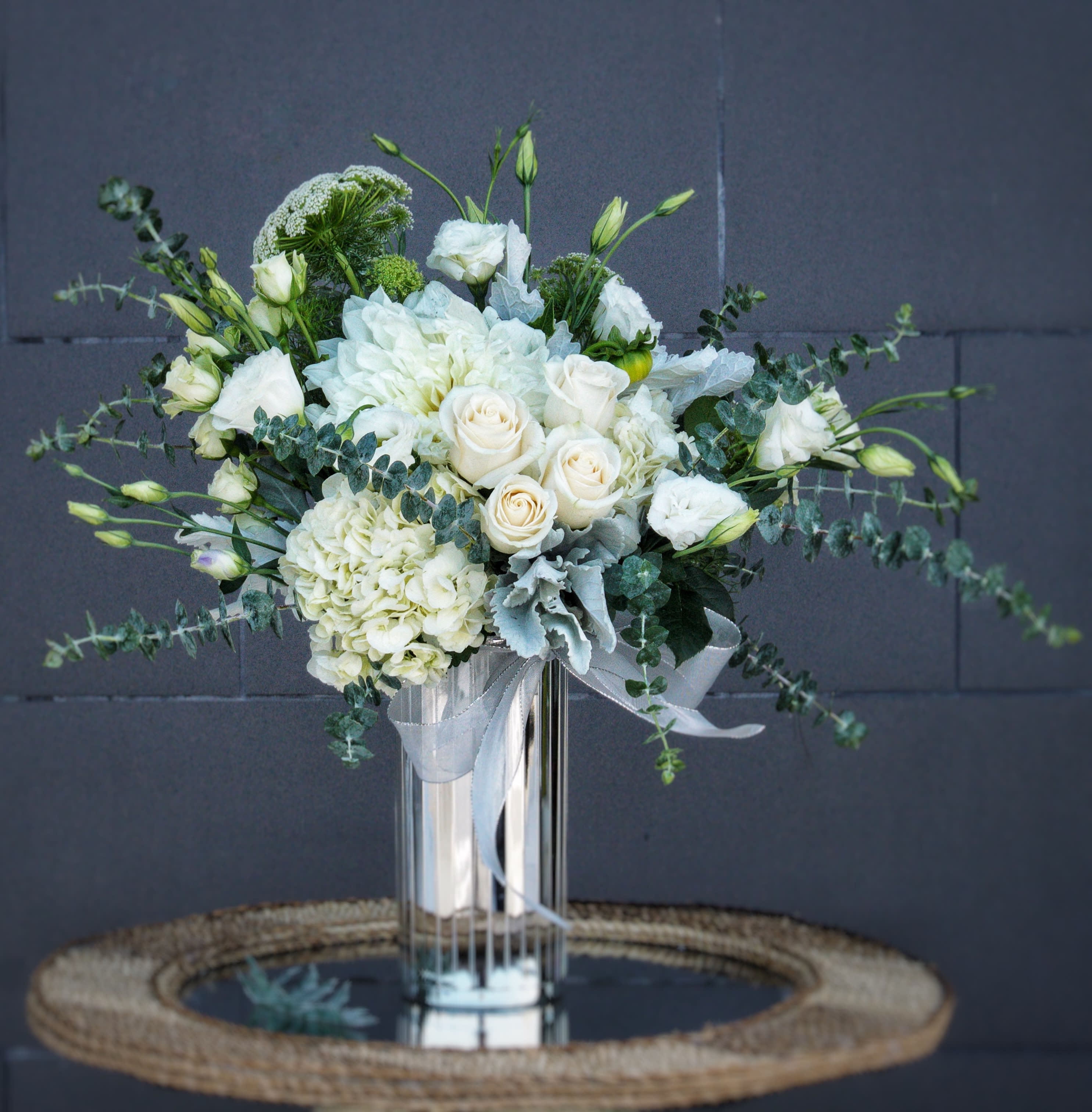 Shining On - Elegant white including rose, soft lisianthus, hydrangea... and nice accents in a silver vase.