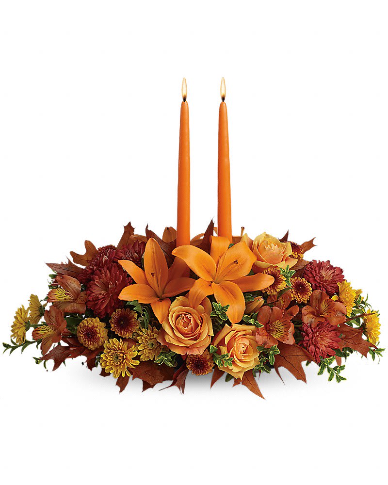 Family Gathering Centerpiece Family Gathering Centerpiece - As your loved ones gather around the table, they'll bask in the warm glow of two orange taper candles surrounded by a fantastic array of fall flowers. Orange roses, asiatic lilies, dark orange alstroemeria, bronze button spray chrysanthemums, yellow and rust cushion spray chrysanthemums and fall foliage are exquisitely gathered in this center-of-attention piece.