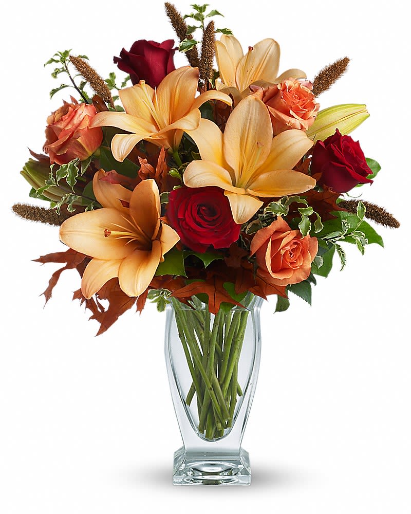 Teleflora's Fall Fantasia - Absolutely exquisite! This bouquet is a fall flower fantasy come true. All the richness of this colorful season is captured in a stylish glass vase. So pretty, you might have to order one for a friend and one for yourself! Beautiful orange and red roses, yellow asiatic lilies, autumn oak leaves and more are beautifully arranged in an exclusive Couture Vase. Isn't fall fantastic?