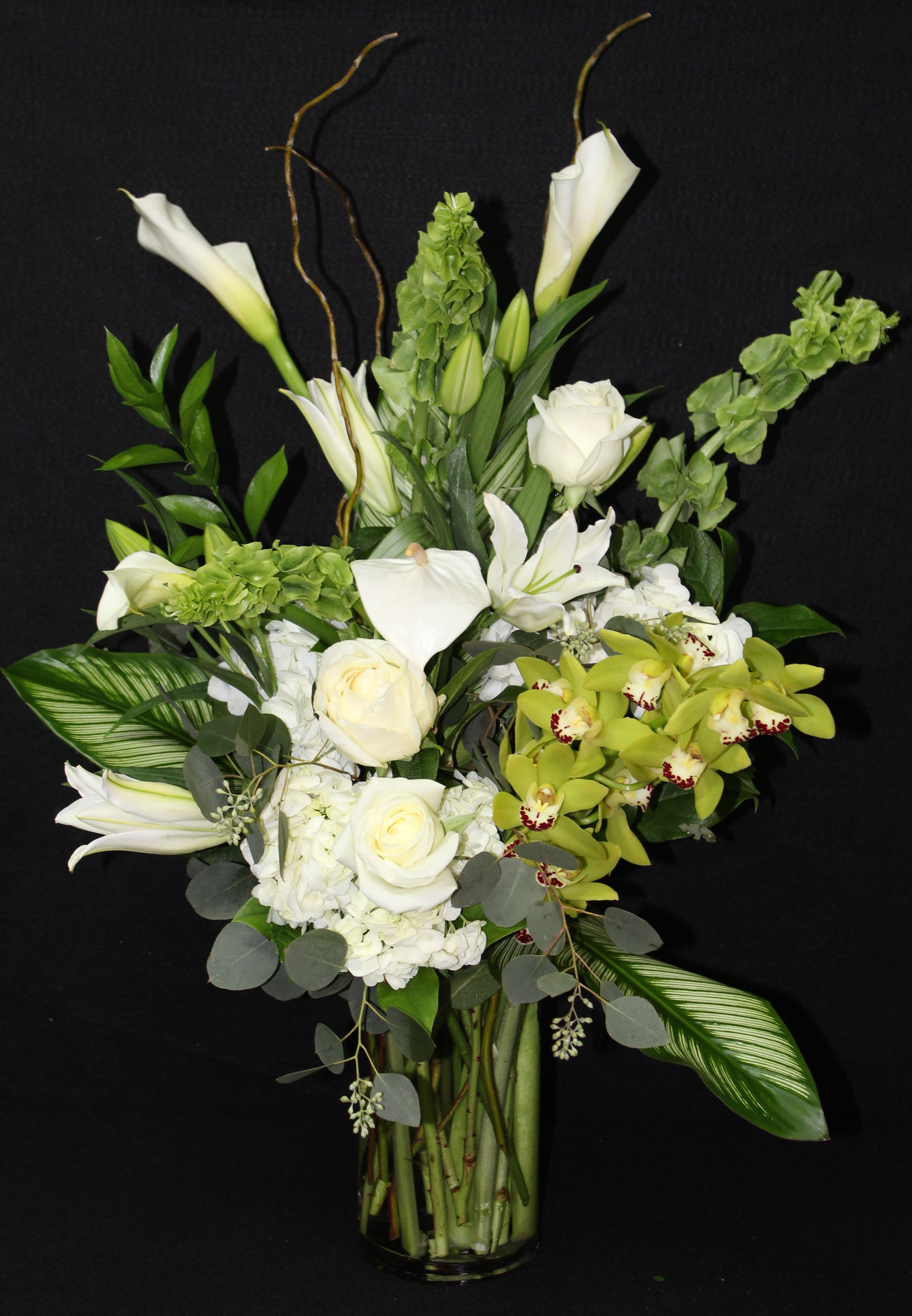 Sophisticated Elegance - Show them you have great taste with this arrangement of white roses, calla lilies, stargazer lilies, green cymbidium orchids, bells or Ireland among greens.