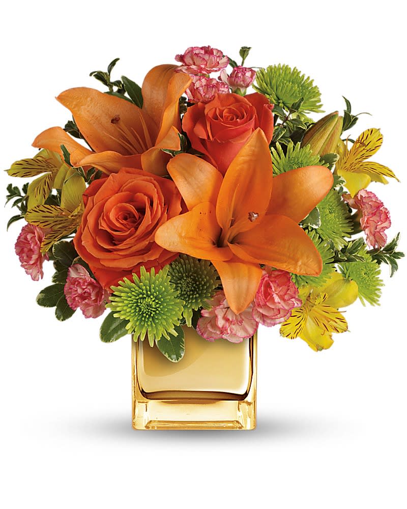 Teleflora's Tropical Punch Bouquet - Glow for it! Capture the magic of a tropical sunset with this gorgeously glowing bouquet. Lush lilies and roses in radiant shades of orange and yellow are presented in a golden Mirrored Cube for a touch of instant glam. Soft orange roses, asiatic lilies and miniature carnations are arranged with yellow alstroemeria and green button spray chrysanthemums. Delicate oregonia and pittosporum add contrast. Delivered in a Mirrored Cube.