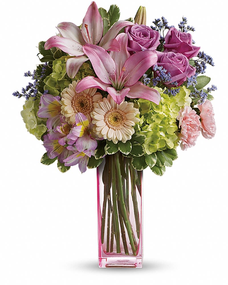 Teleflora's Artfully Yours Bouquet - Sweep her off her feet, say Happy Birthday, or simply brighten an ordinary day with the breathtaking beauty of this luxurious arrangement. Hand-delivered in a gorgeous pink glass vase, this mix of hydrangea, roses, lilies and gerberas is a gift she'll never forget! Surprise them with this bouquet of green hydrangea, lavender roses, crÃ¨me spray roses, pink asiatic lilies, miniature peach gerberas, pink alstroemeria, light pink carnations, lavender limonium and variegated pittosporum. Delivered in a pink vase.