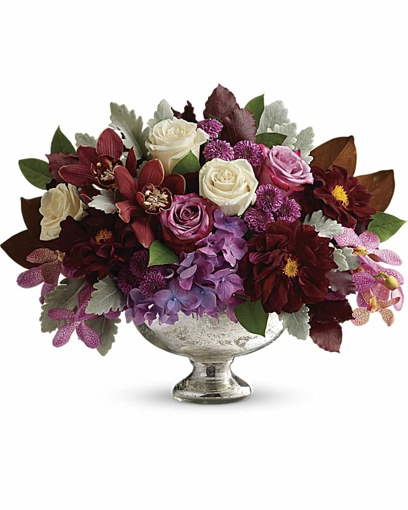 Teleflora's Beautiful Harvest Centerpiece - Take your fall dÃ©cor to a sophisticated new level with this breathtaking bouquet of deep purple blooms, presented in a timelessly elegant mercury glass bowl. This lush arrangement features purple hydrangea, red cymbidium orchids, purple mokara orchids, crÃ¨me roses, lavender roses, burgundy dahlias, purple button spray chrysanthemums, magnolia leaves, dusty miller, burgundy copper beech, and lemon leaf. Delivered in Teleflora's Mercury Glass Bowl.
